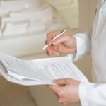 Médico de jaleco branco preenchendo formulário e solicitando exame ao paciente, ilustrando pedido médico negado pelo plano de saúde