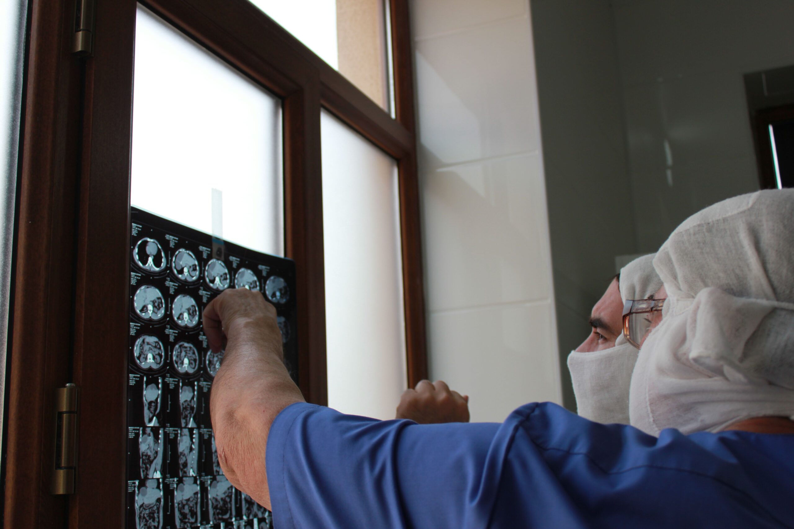 Médico analisando exames de imagem do cérebro após plano de saúde negar radiocirurgia